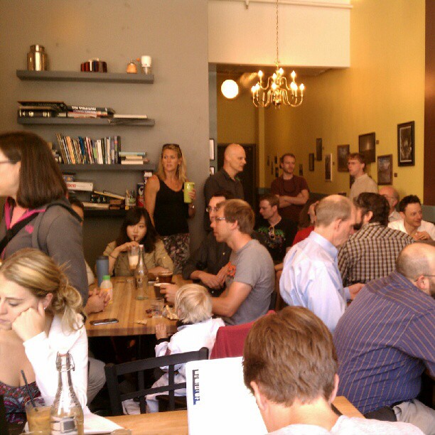 group of people seated around a wooden table in a dining room