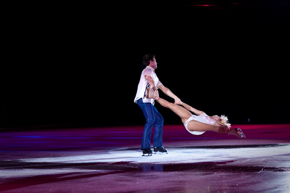 a man and woman are performing on the ice