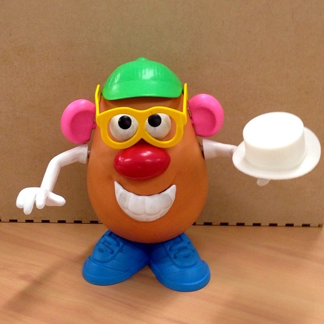 a toy wearing safety goggles and holding onto a cake plate