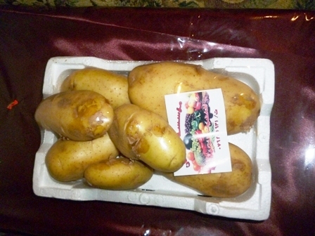 a container full of potatoes next to an open package