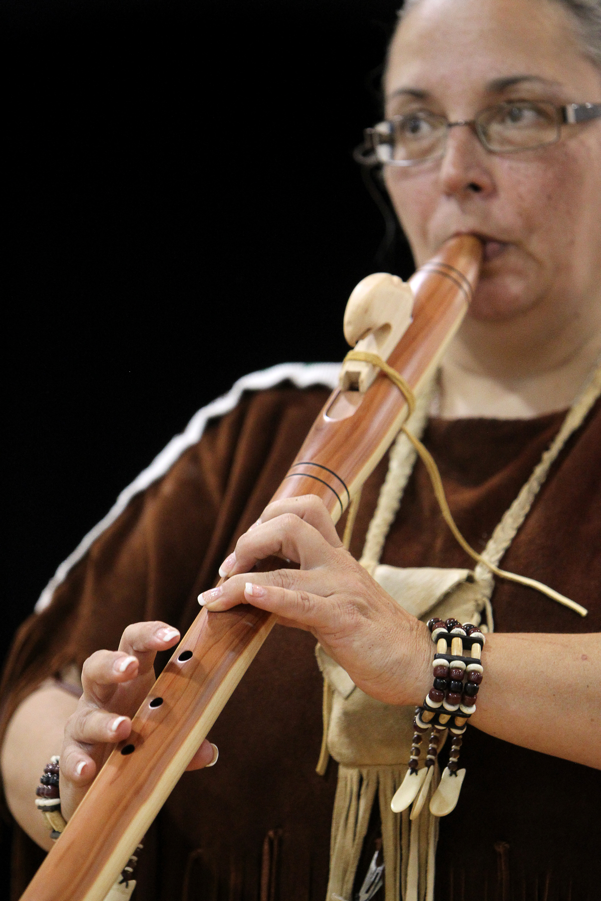 an old woman playing a flute on stage