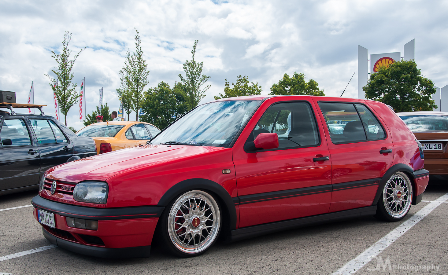 a red station wagon sits in a parking lot