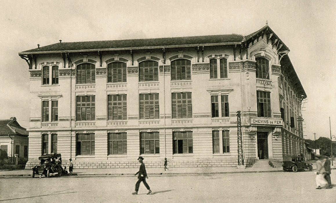 two people are walking past a large building