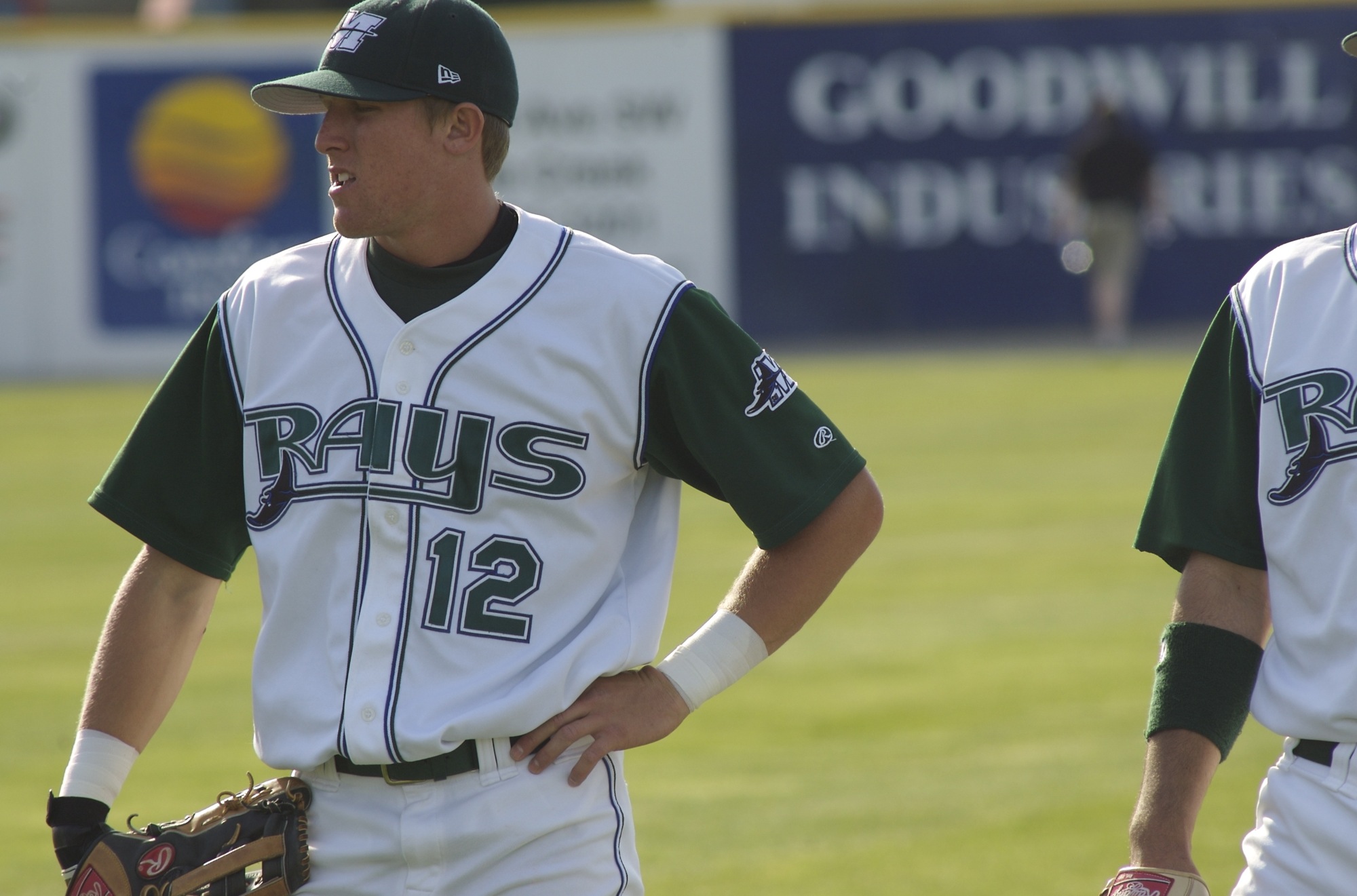 two baseball players standing next to each other in the grass