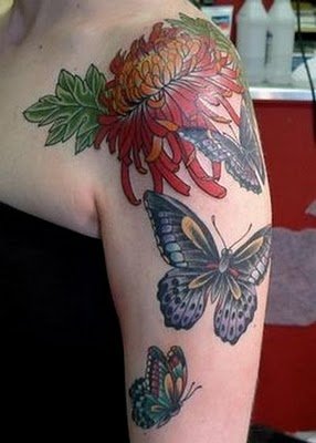 a tattoo of different flowers and erflies is on a girl's arm