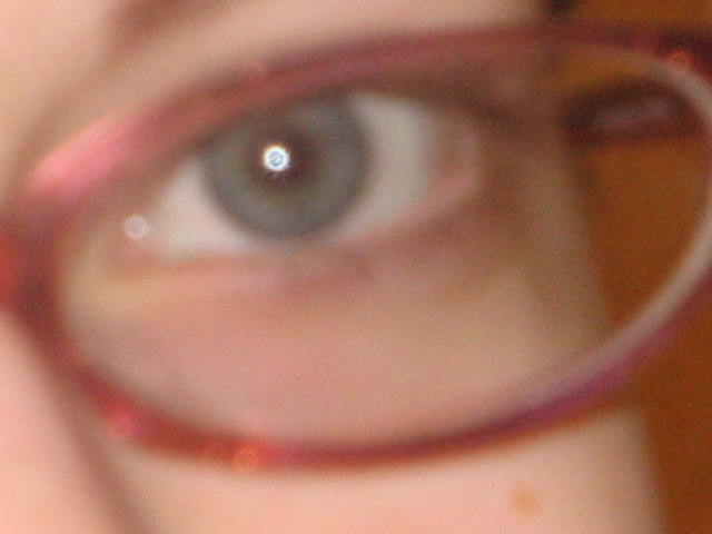 the eye of a person looking through a pair of glasses