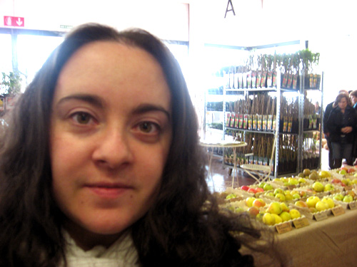 a woman with long hair is next to an assortment of fruit