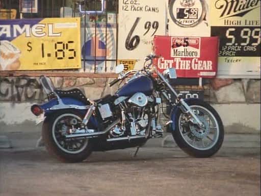 a vintage harley davidson motorcycle parked in front of a gas station