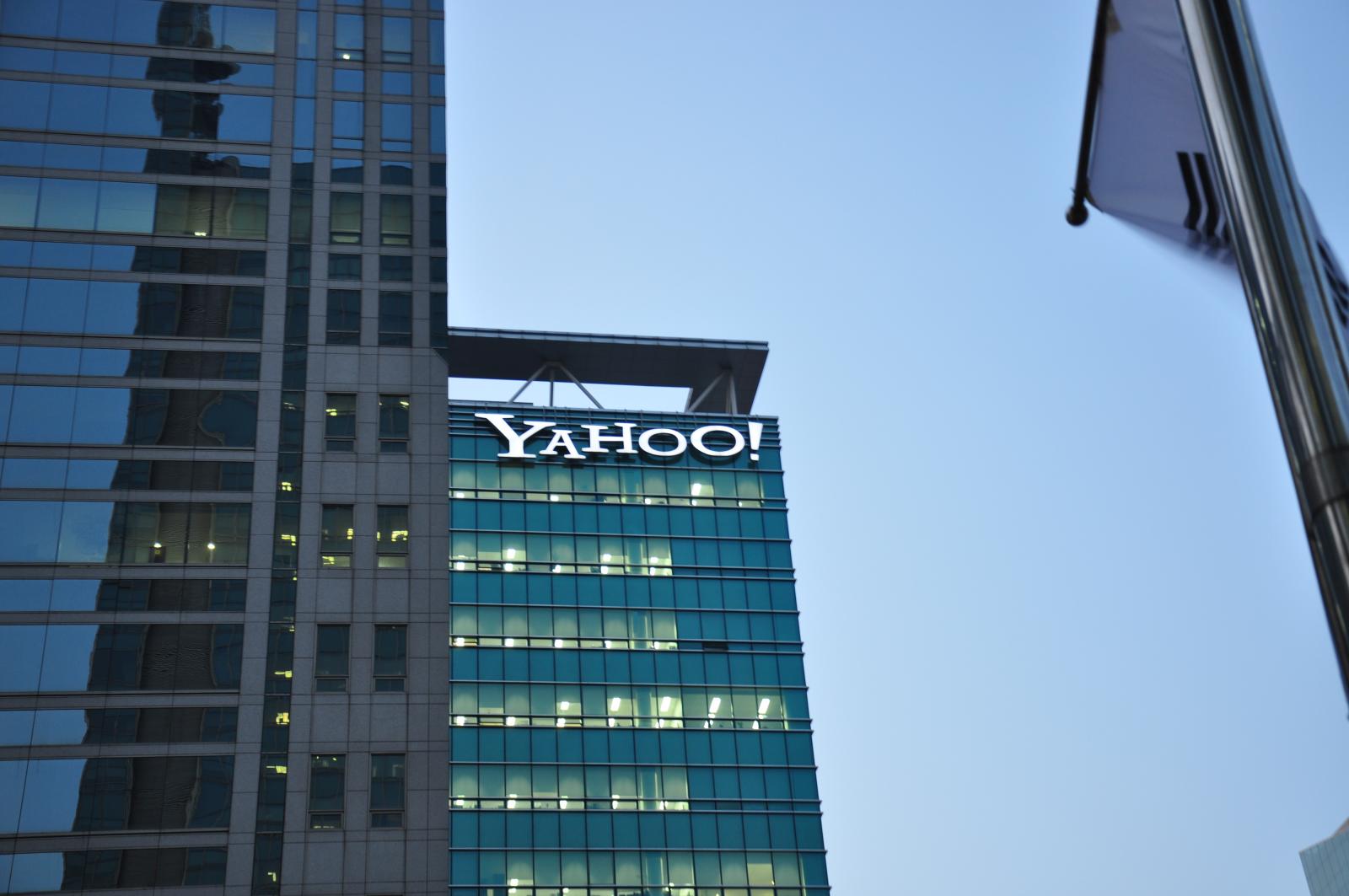 an illuminated yahoo logo atop the company's glass fronted building