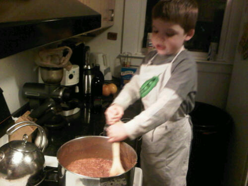 a young child is making food in the kitchen