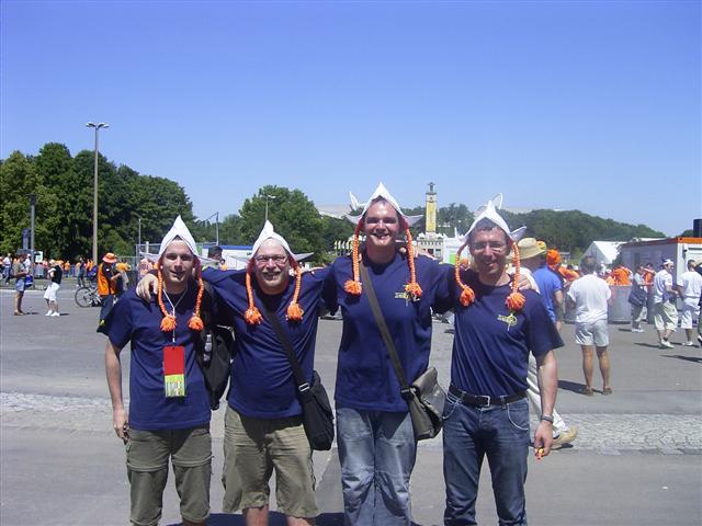 four people wearing party hats are posing together