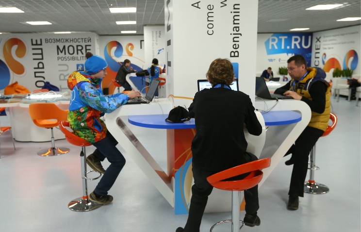 several people sitting at a table in an office building