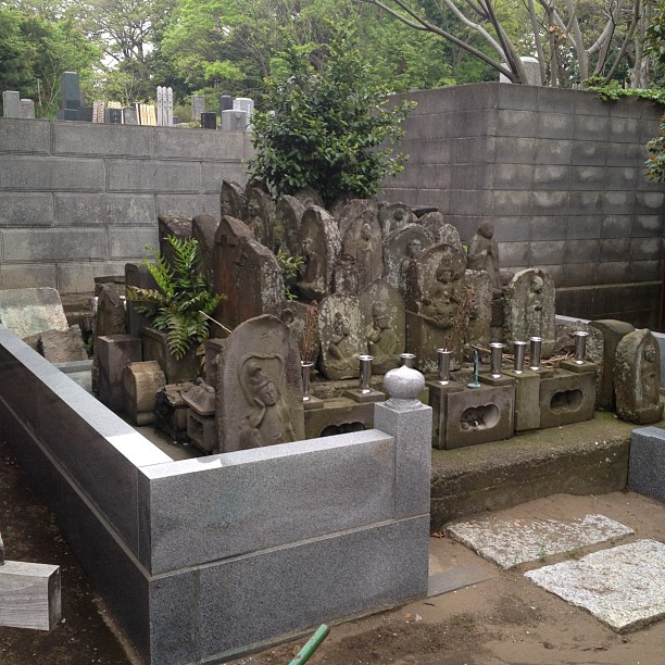 a cemetery with stone sculptures and greenery