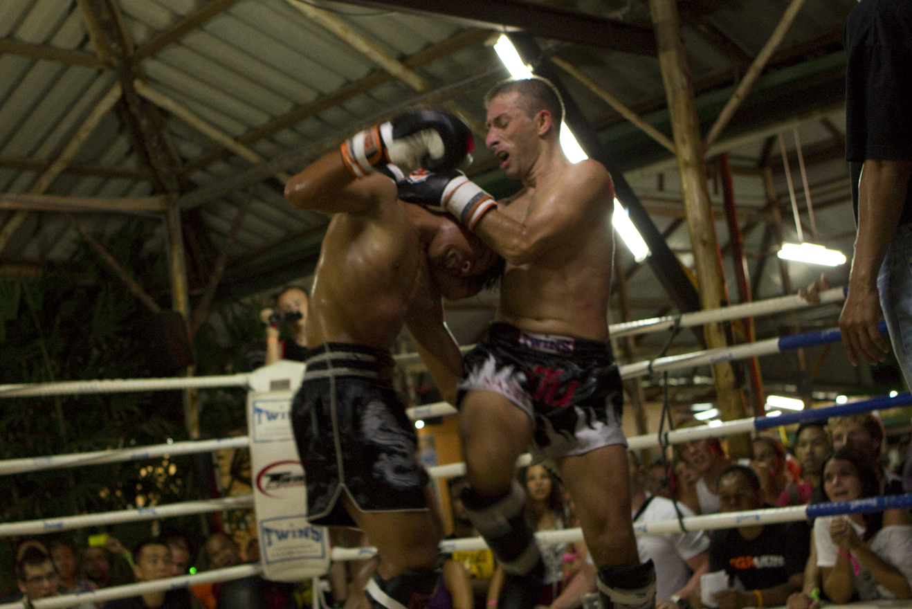 two men fight in front of a crowd