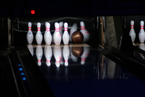 several bowling balls and a pin in a bowling alley