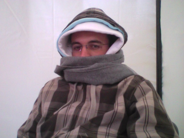 a man with glasses wearing a hooded blanket