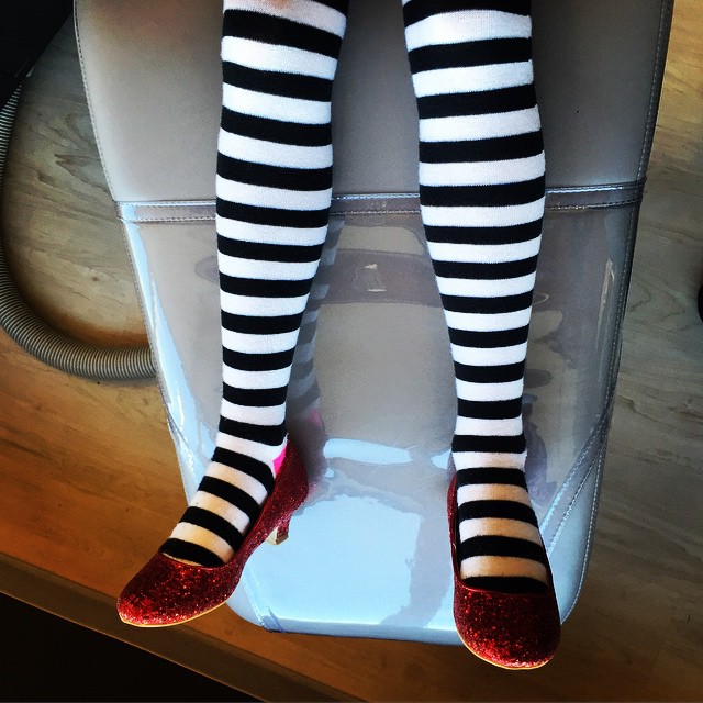a person's legs with long striped socks and black and white socks