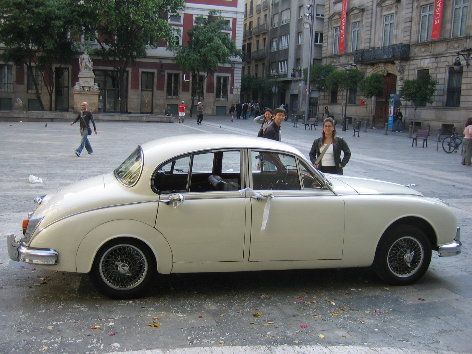 a white vintage car is parked on the street