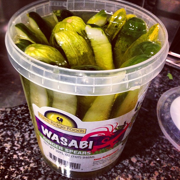 a bucket filled with cucumbers and pickles on a counter