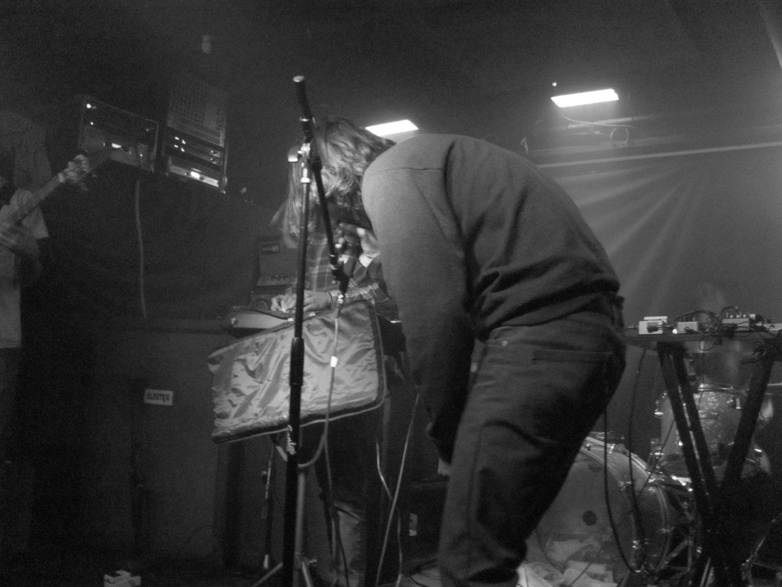 black and white po of man playing guitar on stage