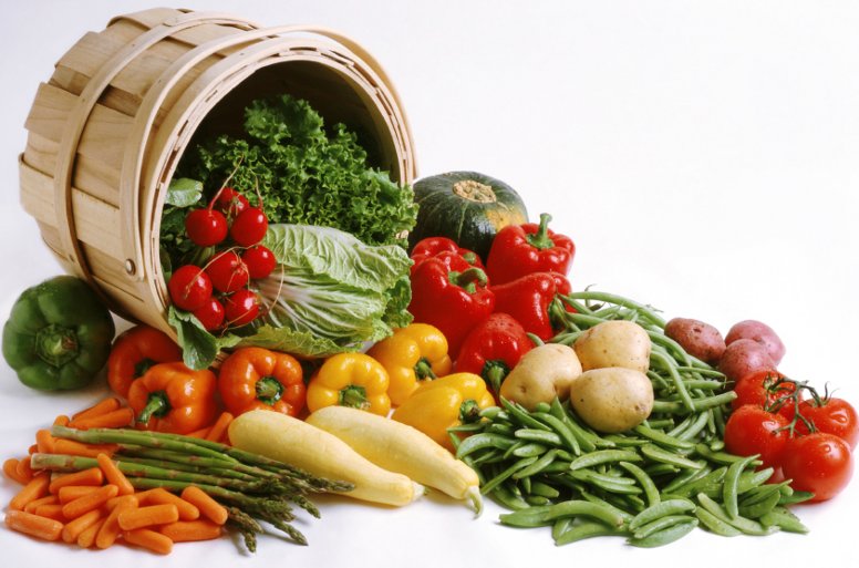 vegetables are on the floor next to a wooden basket