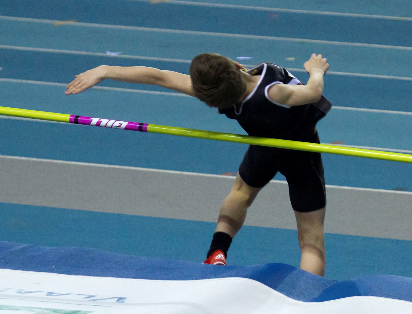 a person on a track holding up a high jump pole