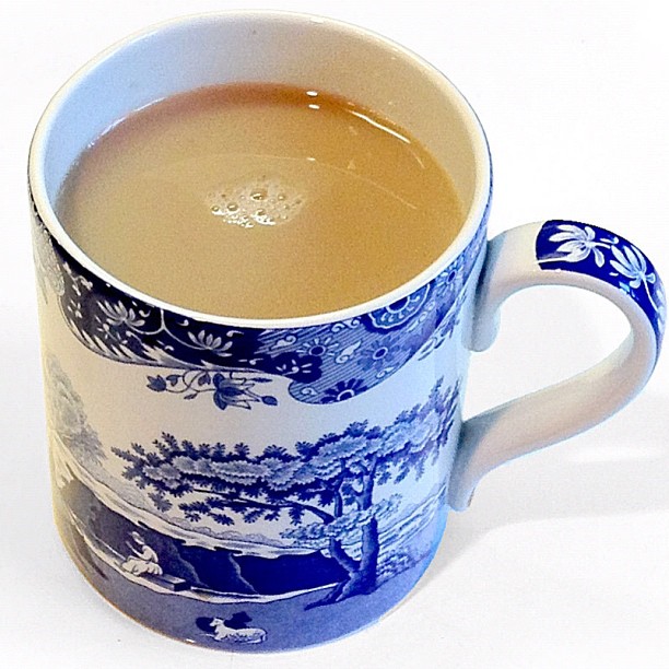 a coffee mug with liquid inside on a white surface