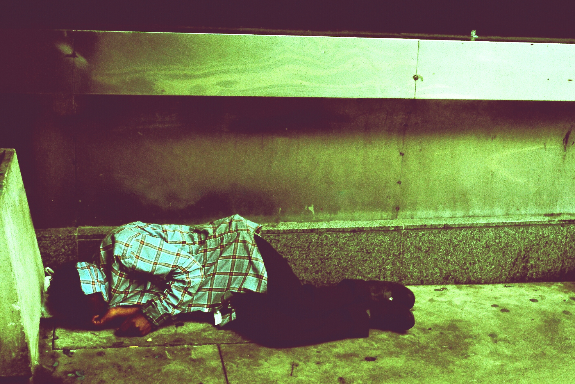 a man laying on the ground next to a metal railing