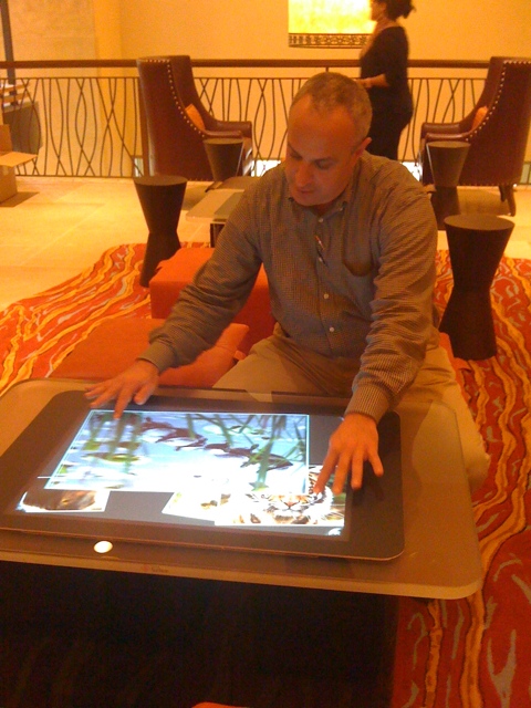 man using an electronic tablet on top of a table