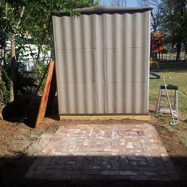 an old - fashioned storage shed is being renovated in a yard