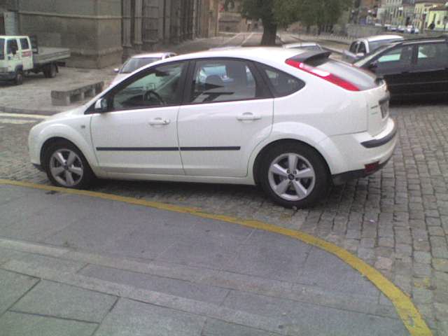 a white car parked on the side of a street