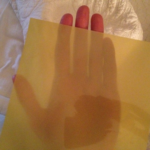 a person is holding onto a yellow piece of paper with their hand