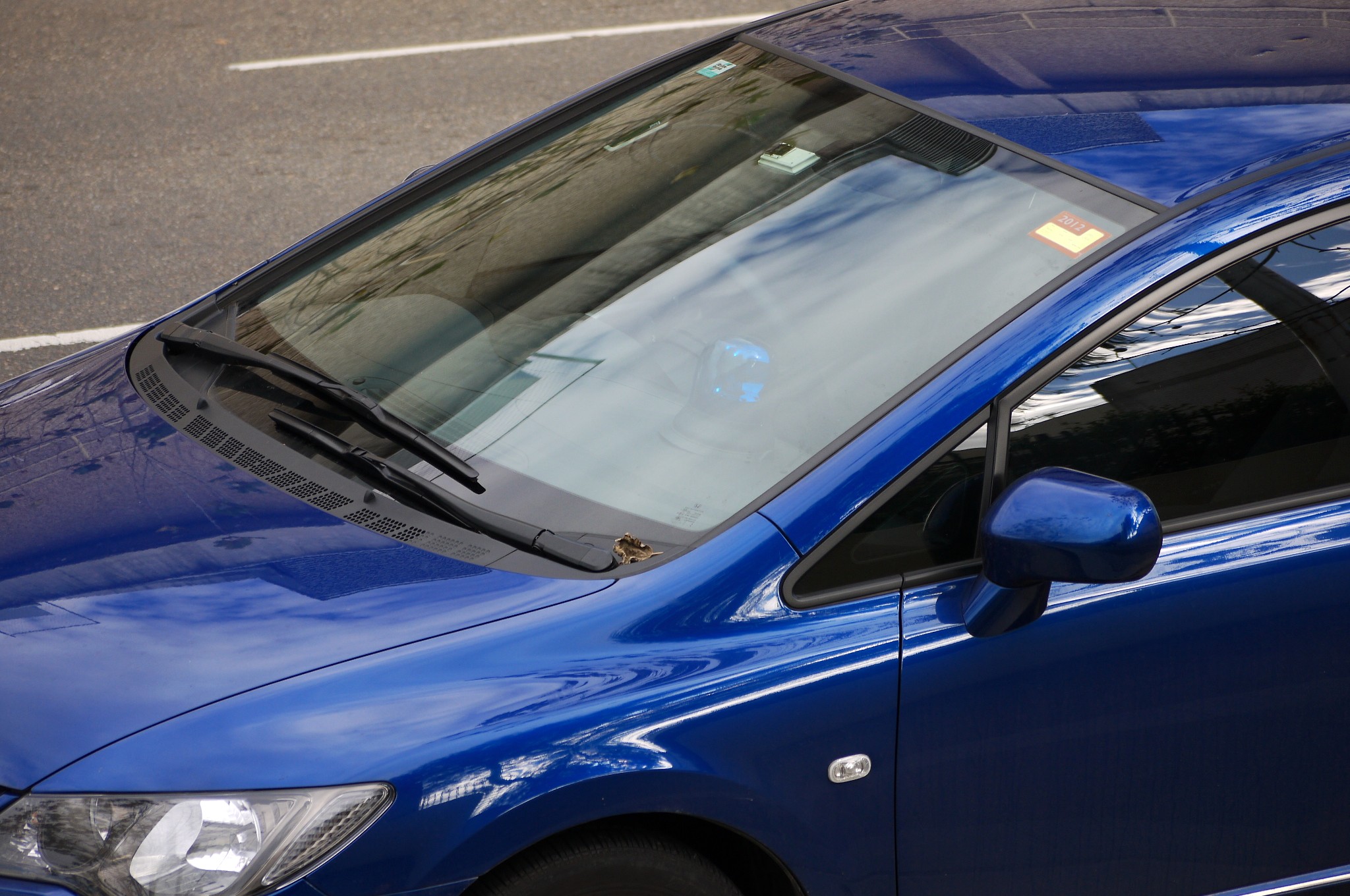 a blue car sits near the curb in front of a building