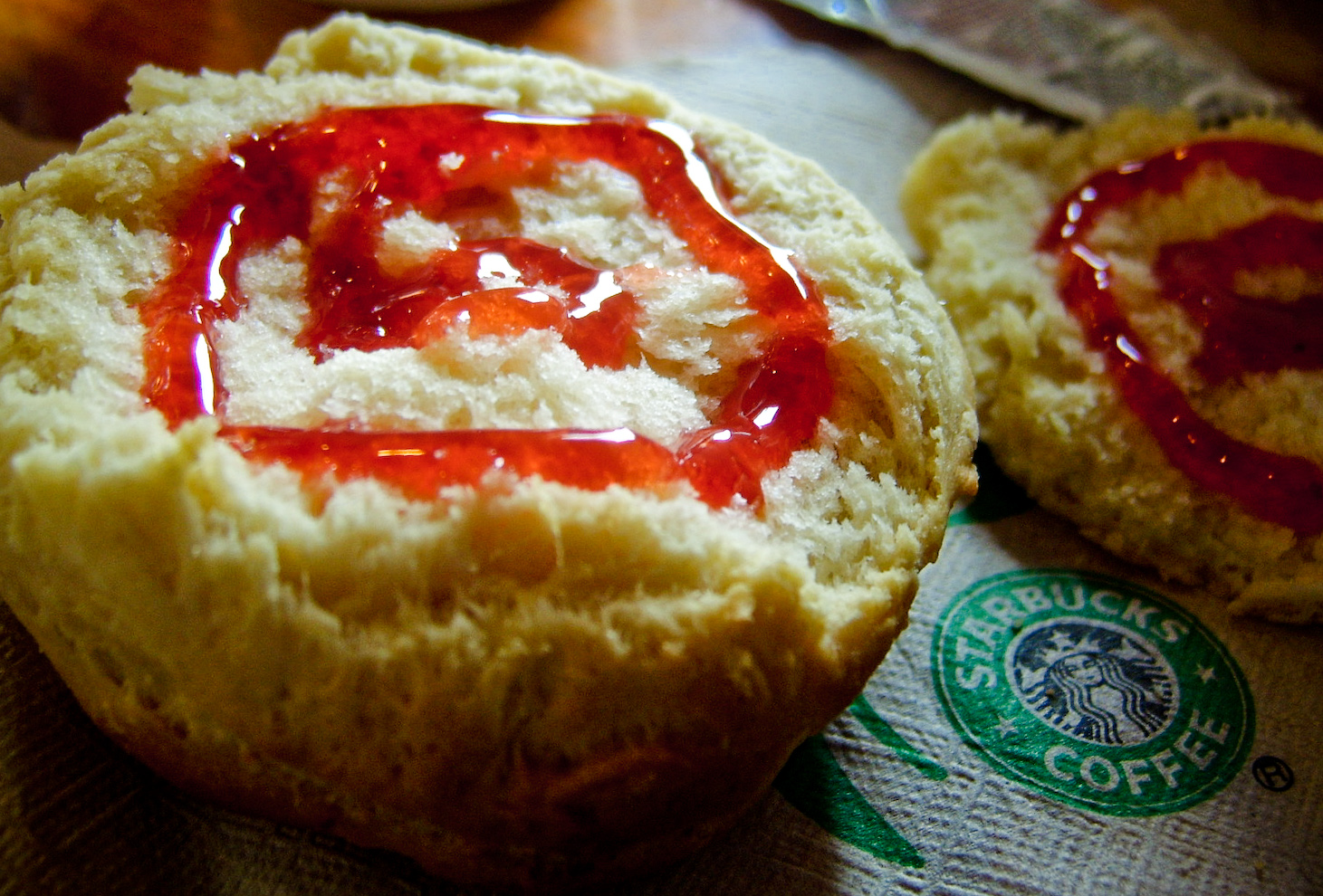 a pastry with ketchup on it sitting next to a sandwich