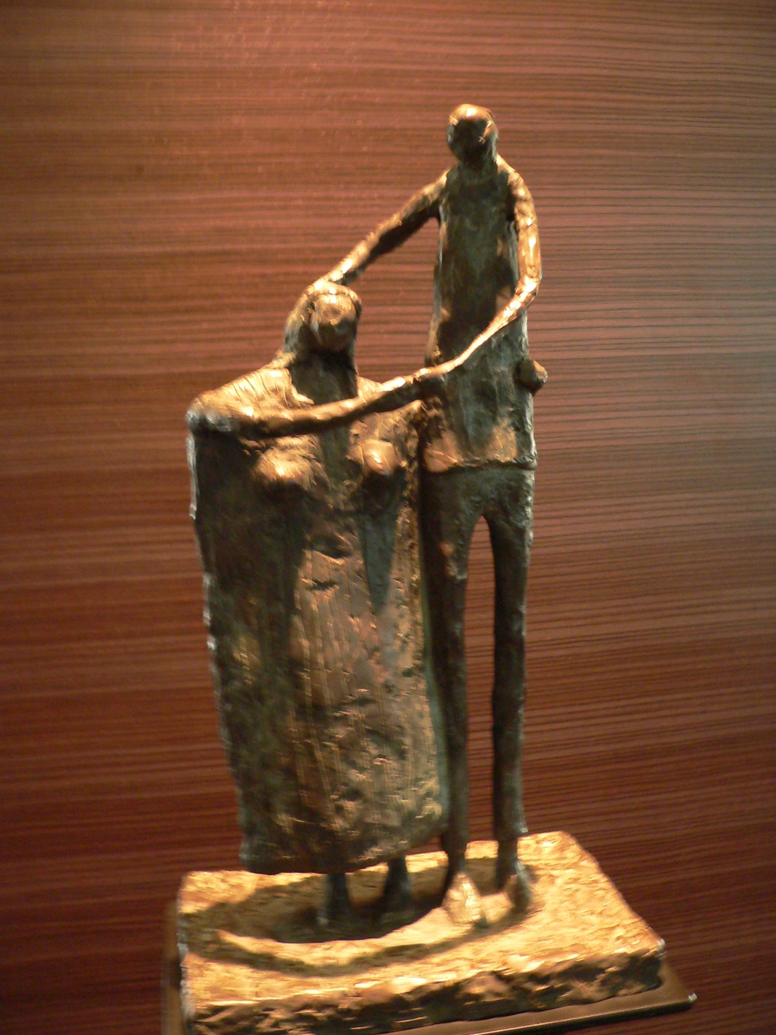 a statue of two men sitting in a trash can
