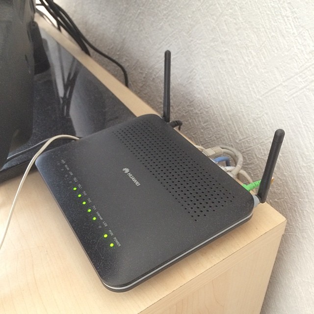 an router sits atop a table near some cords