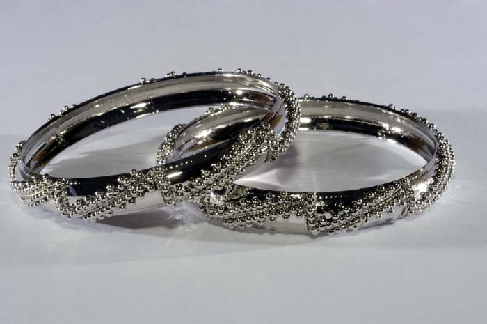 silver wedding rings sit on a white surface