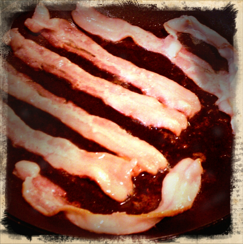 bacon cooking in a pan on the stove