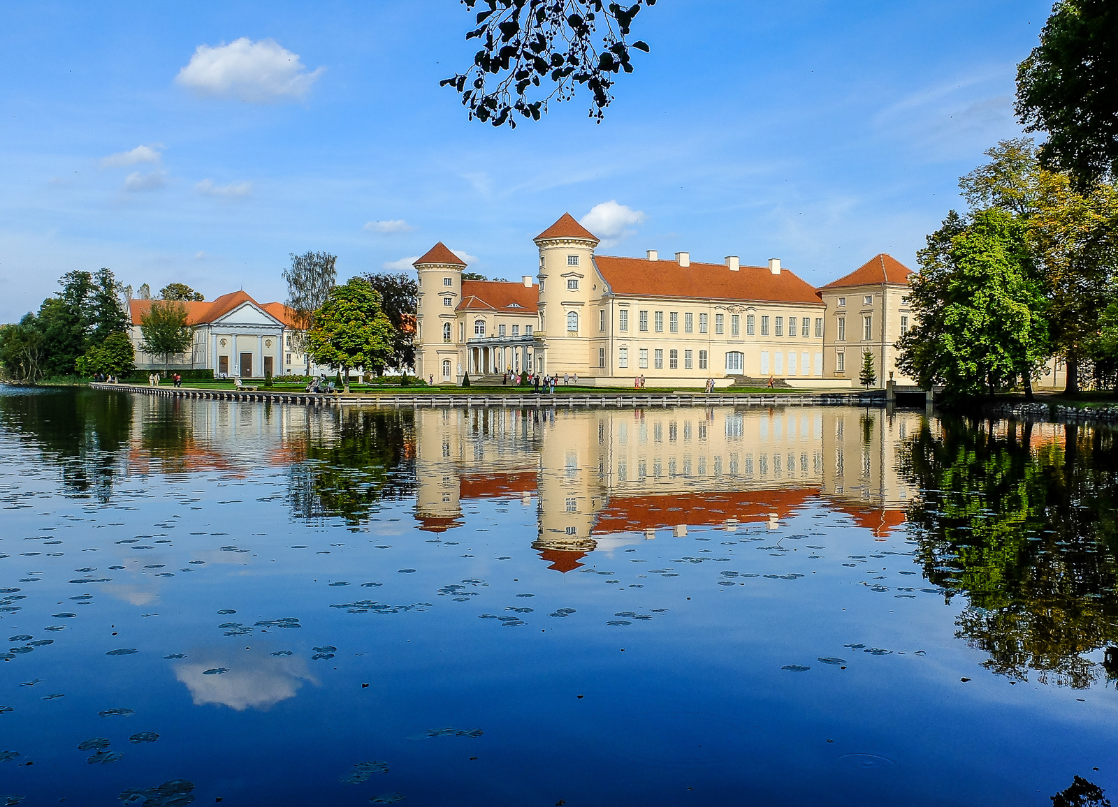 a building sitting on top of a lake next to trees