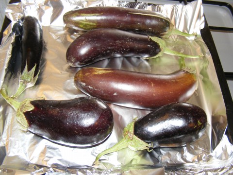 four eggplants sitting on an aluminum foil