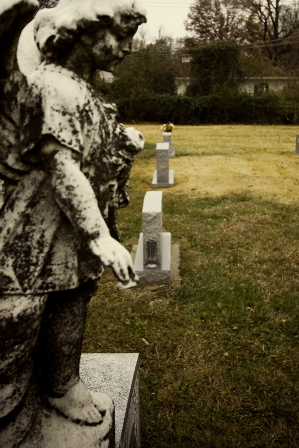 some small statues of children on headstones