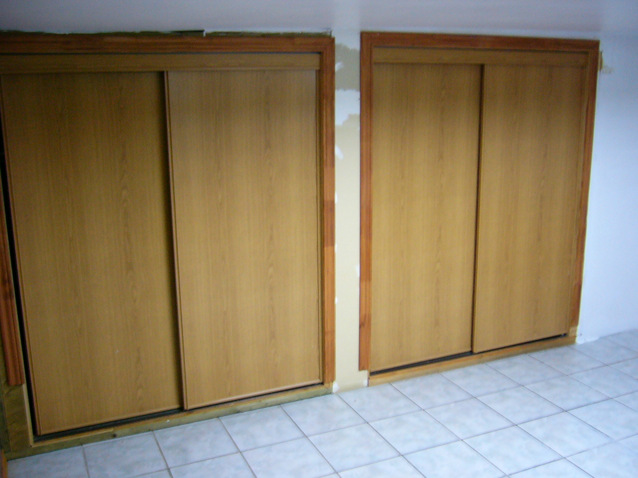 wood cupboards with door and tile floor in empty room