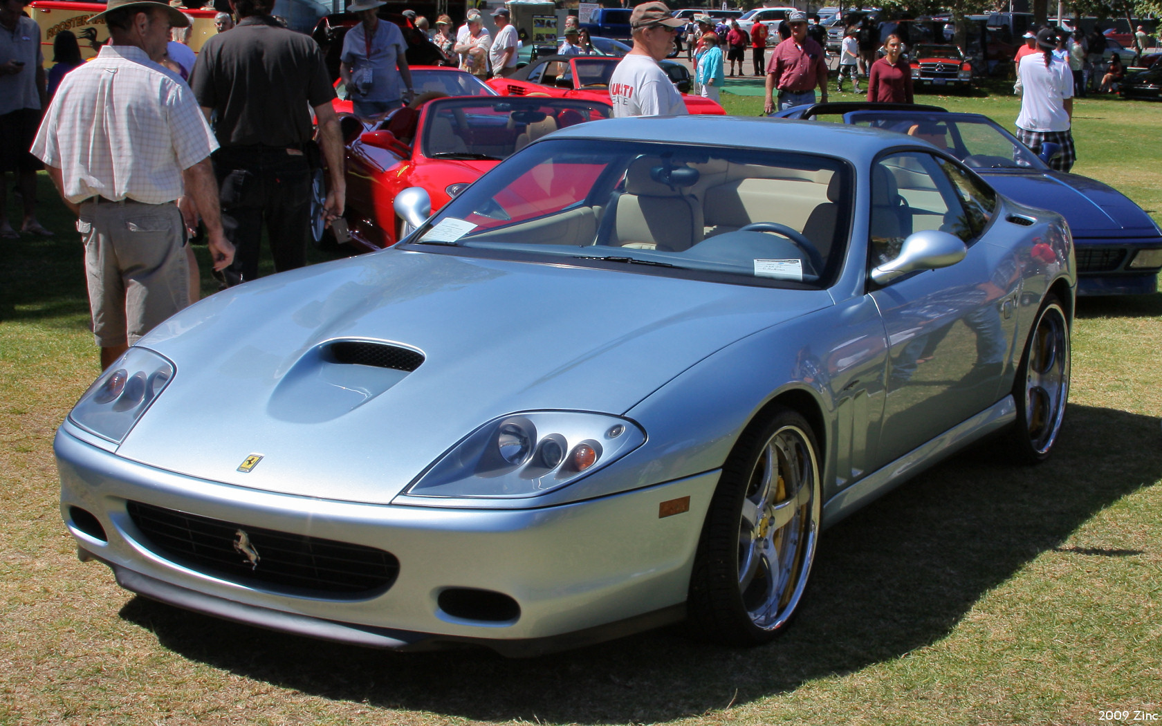 several silver sports cars sitting next to each other on a field