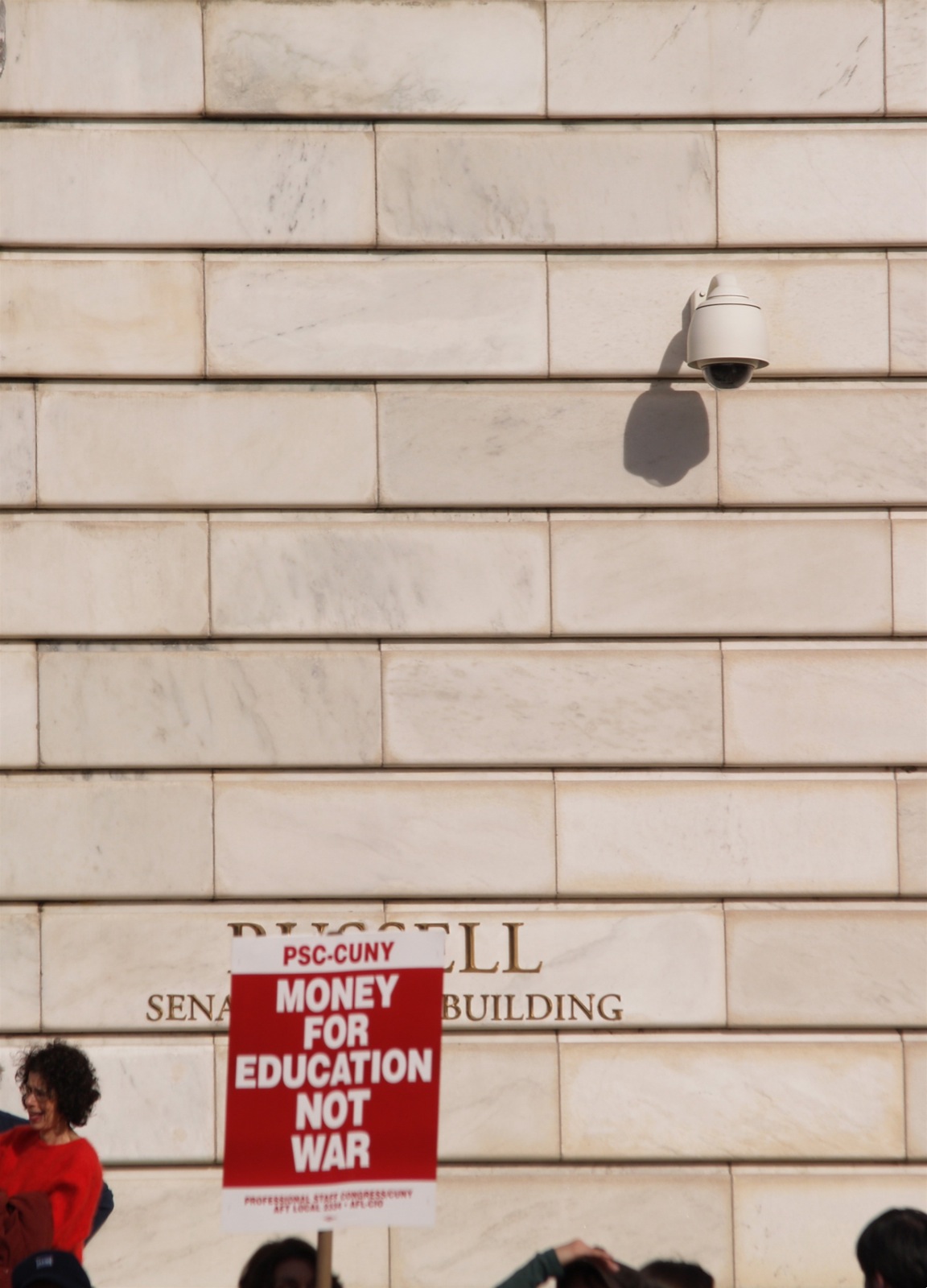 a sign on a sidewalk in front of a wall