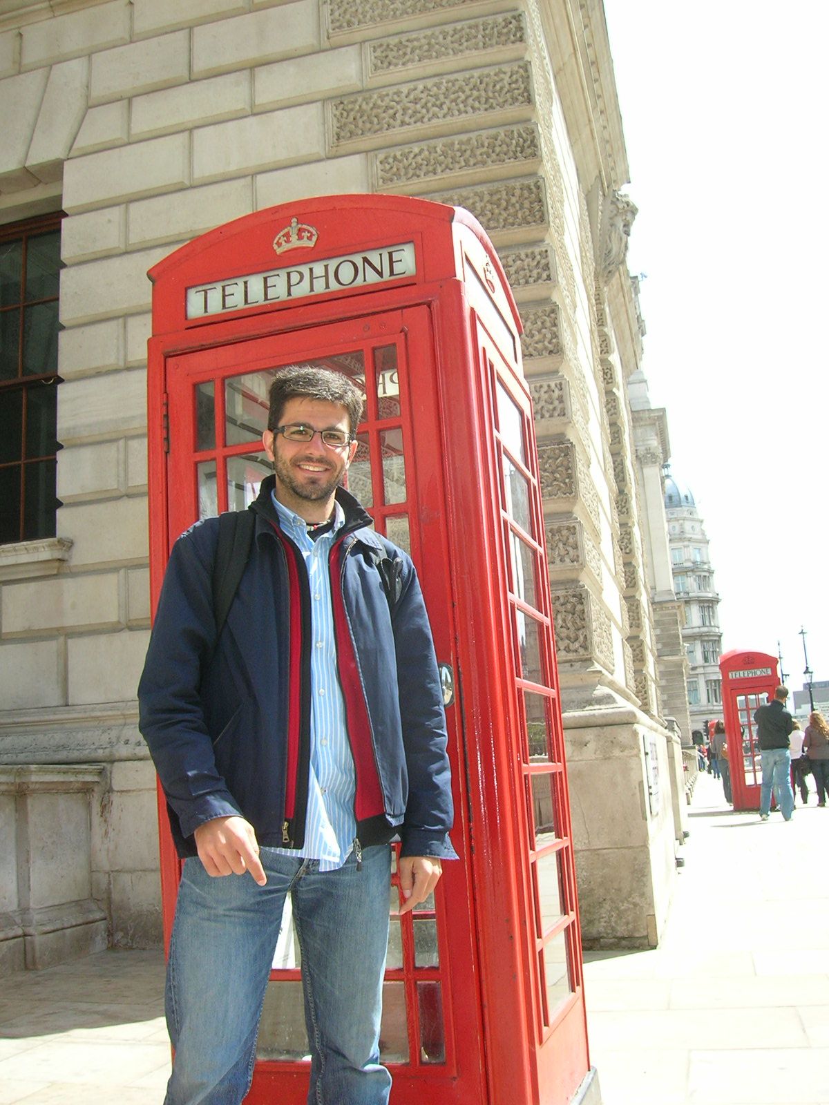 a man is standing next to the phone booth
