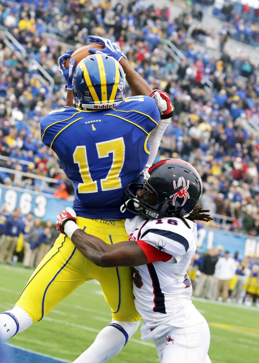 a player leaps high to grab the ball during a football game