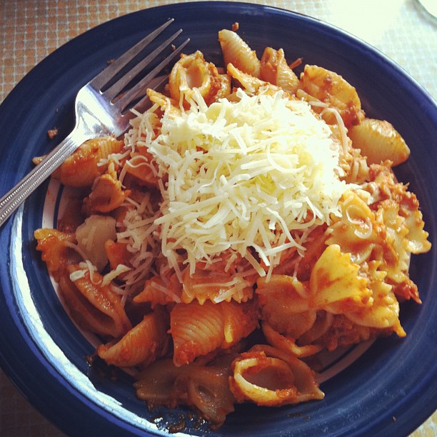 a plate full of pasta with grated cheese on top