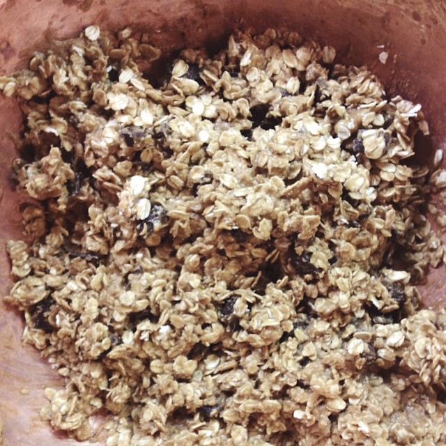 a bowl filled with granola sitting next to a white cup