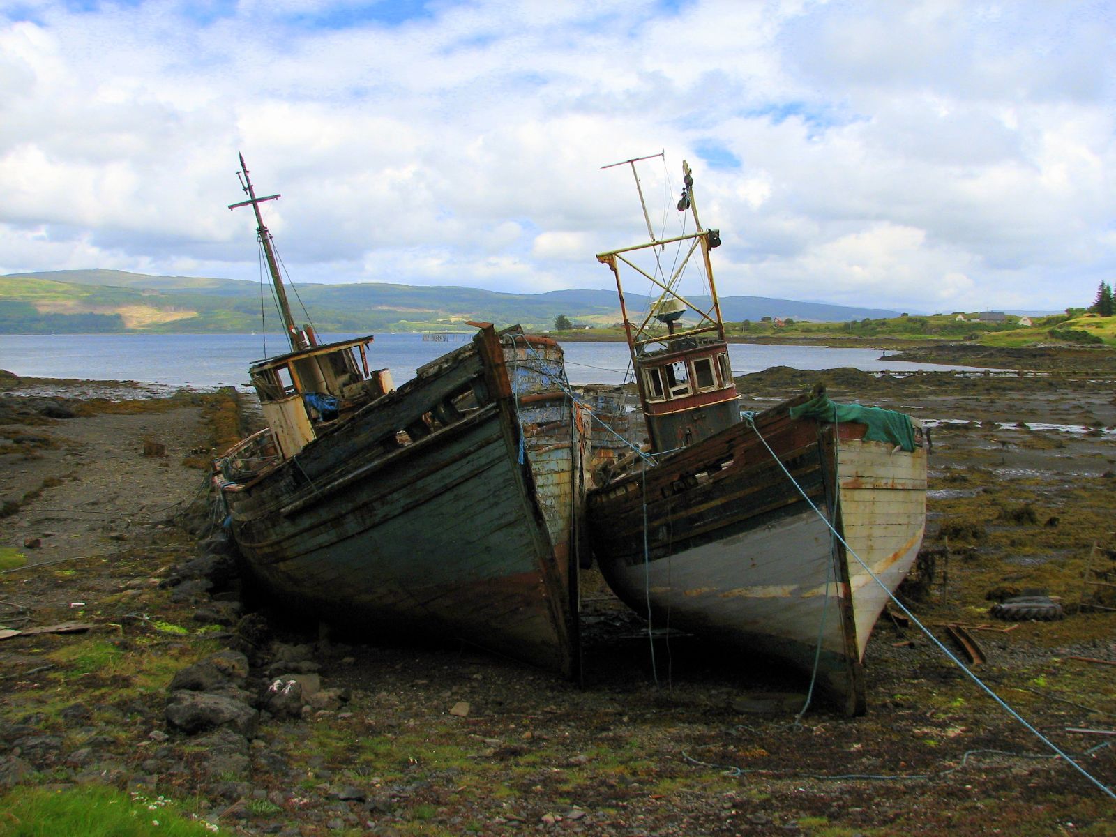 an old boat laying in the mud by the water