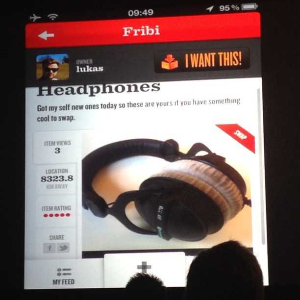 a cellphone screen shows a webpage with a pair of headphones on it